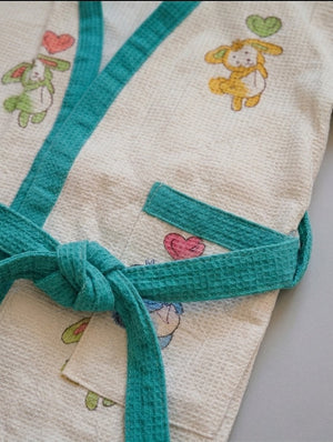 Children's cover-up with bunny characters and a belt on a light background