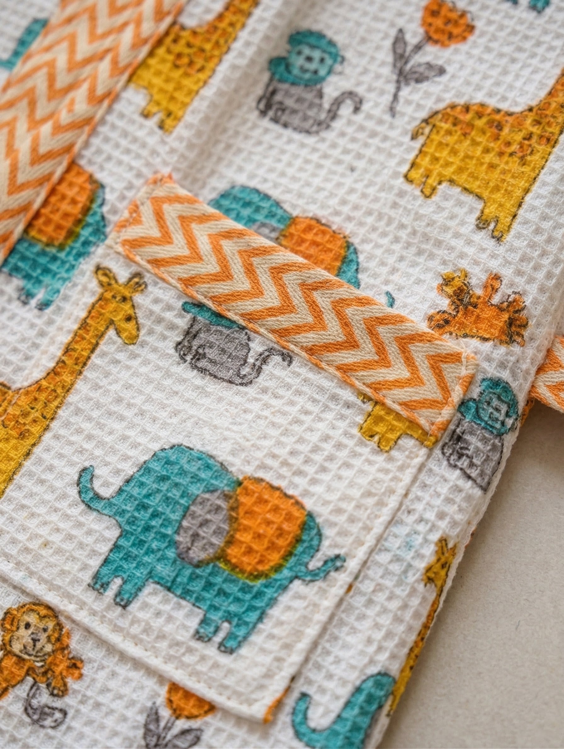Kids Cover-up with animal patterns including elephants, giraffes, and monkeys on a white background.