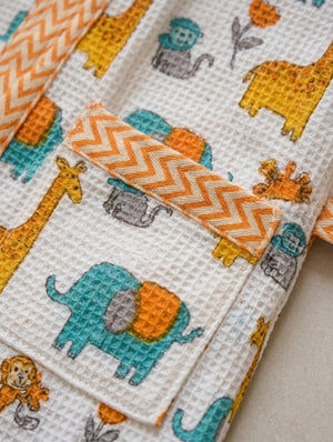 Kids Cover-up with animal patterns including elephants, giraffes, and monkeys on a white background.